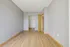 Spacious and modern bedroom with sleek hardwood flooring, neutral gray walls, and ample closet space, perfect for personalized styling.