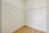 Spacious walk-in closet with sleek shelving and modern hardwood floor, perfect for stylish organization.