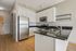 Modern kitchen with gleaming stainless steel appliances, elegant white cabinetry, and sleek subway tile backsplash.