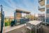 Chic rooftop terrace featuring a modern outdoor kitchen and dining area with stunning city views.