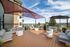 Inviting rooftop lounge with contemporary seating, a stylish pergola, and stunning city views.