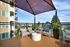 Charming balcony with modern patio furniture and cityscape views, perfect for relaxation and entertaining.