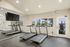 Modern fitness center with treadmills facing a large mirror and bright windows offering scenic outdoor views.