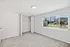 Bright and airy bedroom with plush carpeting, featuring a spacious closet and large window overlooking a lively cityscape.