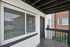 Inviting apartment exterior with modern white brick finish and a cozy private balcony.