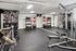 Contemporary home gym boasting modern exercise equipment, mirrored walls, and chic botanical wallpaper for an invigorating workout atmosphere.