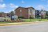 Inviting apartment complex with modern design and lush landscaping, prominently featuring the 'reNEW Alexandria' signage.