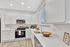 Modern kitchen with sleek white cabinets, stainless steel appliances, and bright natural lighting.