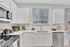 Bright, modern kitchen with sleek white cabinetry, stainless steel appliances, and elegant countertops.