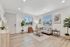 Bright and modern living room with large windows, cozy seating, and stylish decor, perfect for relaxation and entertaining.