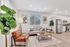 Chic and modern living space with a cozy sofa, stylish armchair, and open-plan kitchen featuring stainless steel appliances. Elegant decor adds a touch of sophistication.