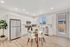 Modern kitchen with sleek stainless steel appliances, elegant white cabinetry, and a cozy dining area on stylish wood flooring.