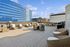 Expansive rooftop patio with modern wicker furniture and sun loungers, offering stunning city views and perfect for entertaining.