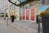 Chic urban entrance to Boston Lofts with vibrant floral arrangements, welcoming steps, and modern glass awning.