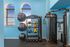 Modern apartment gym with vibrant blue walls, showcasing a versatile fitness area equipped with colorful medicine balls, kettlebells, and a multi-functional exercise machine.