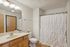 Elegant bathroom featuring a stylish vanity, modern fixtures, and a chic shower curtain in a neutral palette.