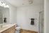 Modern bathroom with sleek fixtures, elegant countertop, and glass-enclosed shower.