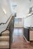 Modern loft apartment featuring sleek staircase, abundant natural light, and stylish open-plan living space with city views.