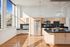 Bright, modern kitchen with stainless steel appliances, sleek countertops, and large windows offering abundant natural light.