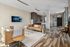 Chic apartment living room with modern decor, featuring stylish leather sofas, elegant wooden flooring, and a cozy fireplace ambiance.