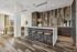 Modern kitchen and living area with stylish wooden flooring, sleek bar seating, and elegant pendant lighting.