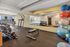 Modern fitness center with various exercise equipment, including treadmills, weights, and yoga mats, offering a bright and inviting workout space.