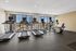Bright and modern fitness center featuring state-of-the-art treadmills and exercise equipment with a stunning city view.