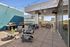 Spacious rooftop terrace with modern seating, grills, and elegant lighting perfect for outdoor gatherings.