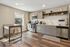 Modern kitchen with sleek gray cabinetry, stainless steel appliances, and natural wood flooring, offering a bright and inviting space.