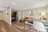 Modern apartment interior showcasing a cozy living area with stylish decor, glass sliding door to dining room, elegant wood flooring, chic seating, and a luminous ambiance.