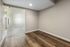 Modern apartment interior with elegant wood flooring and a sleek frosted glass door.
