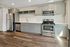 Sleek modern kitchen with stainless steel appliances, elegant cabinetry, and chic wood flooring.