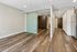 Modern apartment interior showcasing stylish wood flooring, minimalist design, and a sleek glass sliding door.
