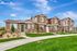 Charming multi-unit townhouse featuring modern architecture, lush landscaping, and clear blue skies.