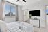 Bright and modern bedroom with large window, stylish decor, and access to an ensuite bathroom; perfect for comfort and relaxation.