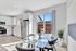 Bright and modern kitchen with stainless steel appliances, elegant glass dining table, and a view of the patio through large sliding doors.