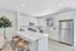 Bright and modern kitchen with sleek white cabinetry, stainless steel appliances, and a spacious island with wooden stools, perfect for entertaining.
