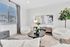 Modern living room with cozy curved chairs, stylish wooden coffee table, artistic wall decor, and abundant natural light from large window.