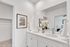 Elegant bathroom with double vanity, pristine white cabinets, and stylish modern decor in a chic apartment.