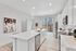 Modern kitchen with sleek white cabinetry, stainless steel appliances, and an elegant island with pendant lighting.