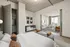Modern urban apartment showcasing a cozy bedroom with elegant decor, leading into a sunlit living room with panoramic city views.