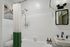 Elegant bathroom with vintage charm featuring a sleek white bathtub, modern shower fixtures, and a stylish wall mirror.