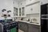 Charming vintage kitchen with retro appliances, stylish black and white cabinetry, and sleek countertops.