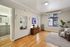 Bright living room with elegant hardwood floors, cozy armchair, and natural light pouring through large windows, creating a welcoming atmosphere.