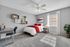 Bright and modern bedroom featuring a stylish single bed with red accents, a sleek desk area, and elegant wall decor, perfect for a cozy and inviting atmosphere.