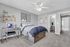 Modern bedroom featuring a cozy bed with blue bedding, a sleek desk with a laptop, stylish wall art, and a convenient ensuite bathroom.