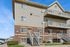 Charming townhouse exterior featuring elegant brick and siding design with multiple balconies and tidy landscaping.