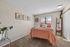 Cozy bedroom with warm orange bedding, decorative wall art, and a plush carpet for a welcoming ambiance.