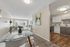 Bright and modern apartment with an open-concept living and dining area, featuring elegant glass dining table, stylish decor, cozy seating, and a well-equipped kitchen with sleek cabinetry.