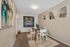 Chic dining area featuring modern glass table, contemporary artwork, and vibrant decor accents.